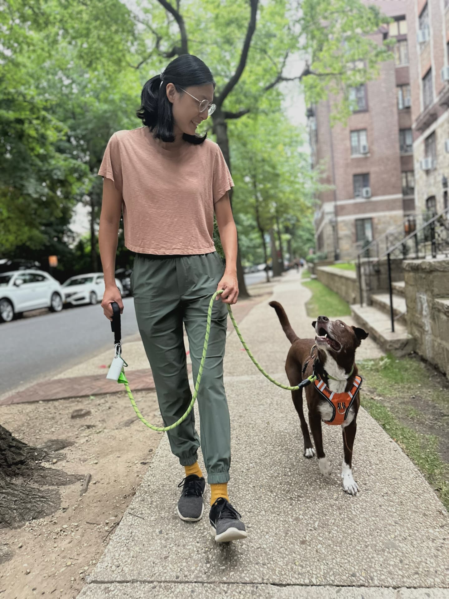 Joyce walking her rescue dog on a Queens sidewalk